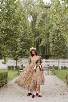 Turn heads year round in our Fauna Dress! The tan chiffon fabric is adorned with vibrant pink and orange embroidered floral, while a gold threaded tulle mid layer adds dimension. The sweetheart neckline, tiered bell sleeves, & maxi-length skirt with embroidered and sequin detailing make this dress an absolute showstopper. A hidden back zipper & full lining ensure a perfect fit. fall aesthetic, pinterset outfit, fall outfit, family photos, country aesthetic, equestrian, floral embroidered Peach Party Dress With Floral Embroidery, Fitted Peach Dress With Floral Embroidery, Tiered Dresses For Fall Garden Party, Fall Tiered Dresses For Garden Party, Spring Beige Maxi Dress For Wedding Guest, Beige Maxi Dress For Spring Wedding Guest, Beige Maxi Dress For Spring Wedding, Spring Floral Print Gold Dresses, Festive Peach Fitted Dress