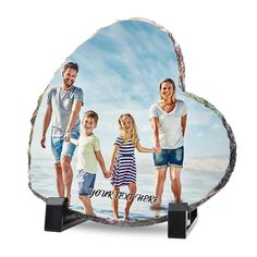 the family is holding hands while standing in front of an oval glass plaque that says your every here