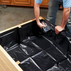 a man in blue shirt and black pants working on an unfinished piece of plastic furniture