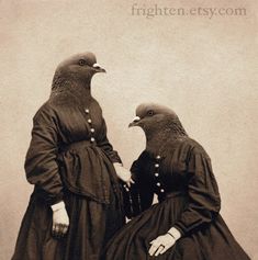 two women dressed in long dresses with birds on their heads, facing each other and standing next to one another