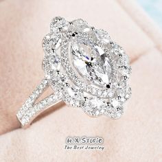 a fancy ring with an oval center surrounded by round diamonds