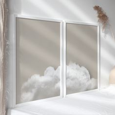 there are two pictures on the wall with clouds in them and one has a vase next to it