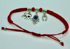 Protect yourself in style with our stunning Red Evil Eye Bracelet, a unique piece that combines the power of ancient symbols with modern fashion. This bracelet features a vibrant red cord adorned with an evil eye charm, an elephant, and a horseshoe, each bringing their own special significance and charm. Key Features: Handmade with Love: Each bracelet is meticulously crafted by hand, ensuring exceptional quality and attention to detail. Powerful Symbols: Evil Eye: Believed to protect against negative energies and bring good luck. Elephant: Symbolizes strength, wisdom, and protection. Horseshoe: Traditionally thought to ward off bad luck and attract fortune. Premium Materials: Made with high-quality alloy charms and a durable red cord that ensures long-lasting wear. Adjustable Size: The bra Red Evil Eye Bracelet, Shoe Bracelet, Red Evil Eye, Powerful Symbols, Bracelet Evil Eye, Evil Eye Protection, Horse Shoe, Bad Luck, Ancient Symbols