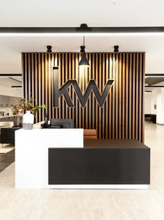 an office lobby with black and white furniture, striped walls and wood paneling on the wall