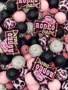 black, pink and white beads that say rodeo babe