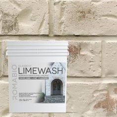 a white brick wall with a sign on it that says limewash next to the door