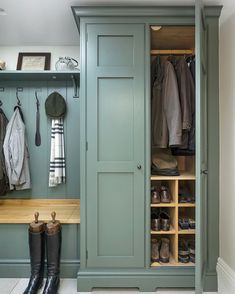 a green closet filled with lots of clothes and boots next to a wooden counter top