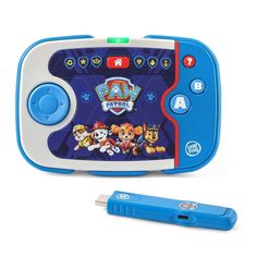 a blue and white electronic device with paw patrol on the screen next to a pen