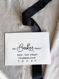 a black ribbon is tied to a white label that says the baker family 822 elm street columbus, ohio