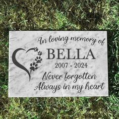 a memorial stone with the words, an loving memory of bella and a dog's paw on it