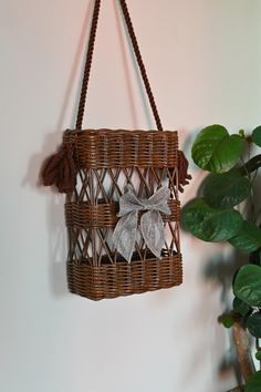 a wicker basket hanging from a wall with a bow on the front and side