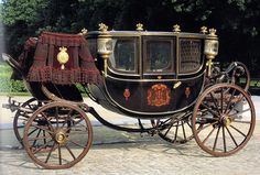 an old fashioned horse drawn carriage parked on the street