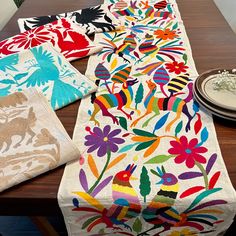 the table is covered with colorfully designed linens and placemats on it