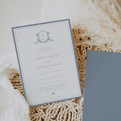 the wedding stationery is laid out on top of a blanket and next to a card