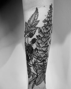 a black and white photo of flowers on the arm, with leaves around it's edges