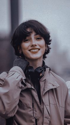 a woman wearing headphones is smiling for the camera