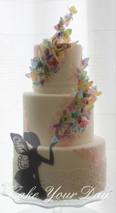 a three tiered cake decorated with butterflies