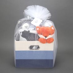 a stuffed animal in a blue and white striped box with tulle on the top