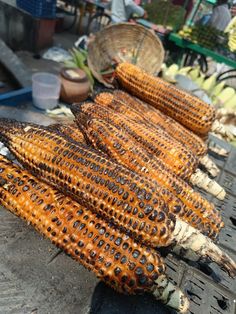 corn on the cob is being grilled and ready to be sold at an outdoor market