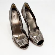 Vintage Gucci Silver Pleated Leather Peep Toe Heels, Size 8.5. Gorgeous Style That Is Timeless. These Silver Pumps Feature The Iconic Logo Encrusted And Gems At The Top Of The Heel. Preowned Condition. Gucci Size 8.5 4” Heel Gg Encrusted Logo Pleated Leather Metallic Silver Peep Toe Leather Heel An9.1 Gucci Silver Designer Heels, Gucci Silver Evening Heels, Gucci Silver Heels For Evening, Silver Gucci Heels For Evening, Silver Designer Gucci Heels, Sleek Silver Patent Leather Heels, Designer Silver Gucci Heels, Metallic Pointed Toe Designer Heels, Designer Metallic Pointed Toe Heels