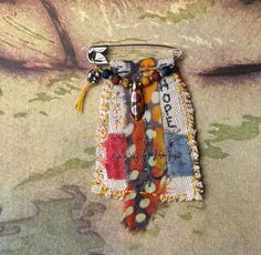 a keychain is decorated with beads and fabric