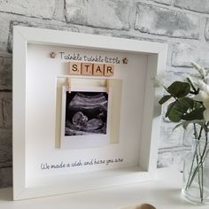 there is a small photo frame with the word sitair on it and a flower in a vase next to it