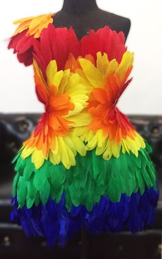 a dress made out of colorful feathers on a mannequin headdress,