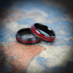 two black and red wedding bands on top of each other