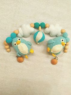 two blue and white knitted birds with wooden beads on a light colored surface next to each other