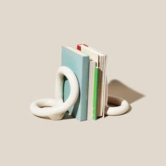 the bookend is shaped like an o - ring and sits next to two books