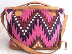 Medium boho pink and black Mexican textile and leather bag.One-of-a-kind and handmade in Mexico.This amazing statement bag is handmade with traditional Mexican stitching and embroidery.Made with 100% cotton fibers and combined with a light tan color 100% genuine leather. This bag measures approximately 22 inches wide by 14.5 inches deep.The base of the bag measures approximately 7.5 inches wide by 17 in length. There is a leather bottom with metal studs for bags protection.There are both strong Bohemian Style Shoulder Travel Bag, Bohemian Style Travel Shoulder Bag, Bohemian Multicolor Bags For Weekend Trips, Multicolor Bohemian Travel Bag For Everyday, Bohemian Tote Bags For Weekend Trips, Bohemian Bags With Leather Handles For Weekend Trips, Multicolor Bohemian Travel Bag For Trip, Bohemian Bags With Large Capacity For Trips, Bohemian Tote Duffle Bag For Weekend Trips