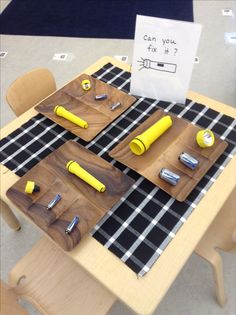 a wooden table topped with cutting boards and yellow utensils on top of it