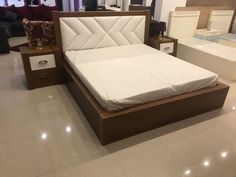 a bed that is sitting in the middle of a room with white walls and flooring