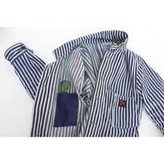 a blue and white striped jacket with green patches on the chest, one buttoned down