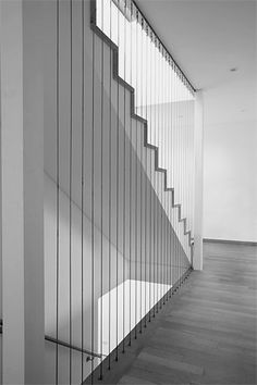 a black and white photo of a stair case in an empty room with wood flooring