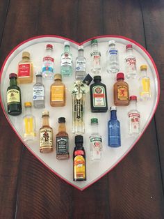 a heart shaped tray filled with different types of liquor