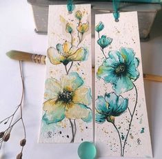 two pieces of paper with flowers painted on them