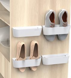 three pairs of shoes are hanging on the wall next to two white shoe rackes