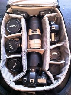 the camera bag is filled with many different types of cameras in it's compartment