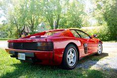 a red sports car parked in the grass