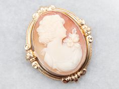 This beautiful vintage cameo brooch pendant features a lovely and proper lady with floral details. She has been set in a simple bezel with a Victorian-style frame, which completes the look of this sweet piece beautifully.This pendant does not come with the chain shown. Please feel free to contact us, we will help you find the perfect chain for your style and budget!Metal: 14K Yellow GoldGem: Shell CameoGem Measurements: 23.1 x 30.1 mm, OvalMeasurements: 32 x 39 mmMarks: "14K" Stamped on the pin clasp Heirloom Cameo Brooch For Wedding, Heirloom Cameo Brooches For Weddings, Heirloom Cameo Wedding Brooch, Victorian Style Cameo Brooch For Weddings, Victorian Cameo Brooch For Wedding, Classic Cameo Brooches For Wedding, Cameo Pendant Brooch For Wedding, Cameo Pendant Brooches For Wedding, Heirloom Cameo Brooch For Formal Occasions