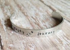 a bracelet that says enjoy and journey on it