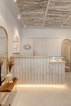 the interior of a store with white walls and wood paneling on the front wall