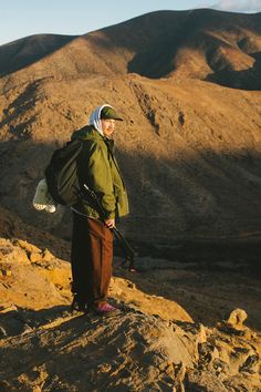 a man standing on top of a mountain holding skis