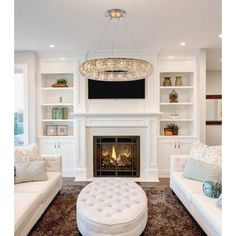 a living room filled with furniture and a fire place in front of a tv mounted on a wall