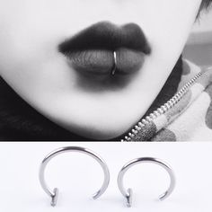 a pair of silver hoop earrings on top of a woman's face with black lipstick