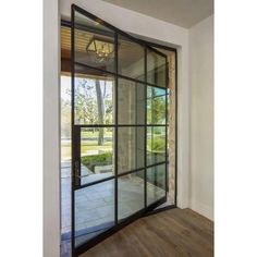 an open glass door leading to a patio area with wood flooring and white walls