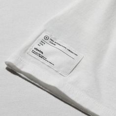 a white t - shirt with a label on the front and back of it's pocket