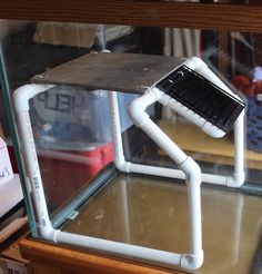 a glass display case with an electronic device in it's holder on the shelf