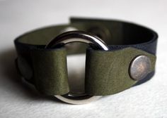 a green leather bracelet with two metal rings